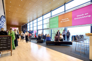 Menschen sitzen und gehen im Seefoyer beim Health & Mind Festival 2023 im Festspielhaus Bregenz