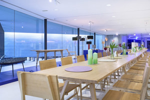 Eine lange Holz-Tafel mit Stühlen im weißen Parkstudio bei der STAGE Bregenz im Parkstudio