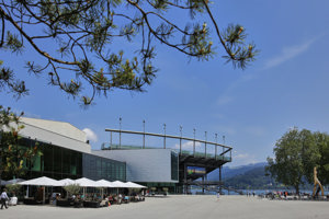 Gäste unter Sonnenschirmen auf der Terrasse des Festspielhaus-Restaurants buehnedrei