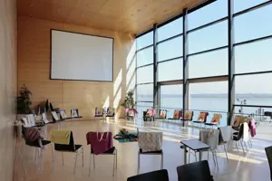 © Anja Koehler Ein großer Stuhlkreis mit bunten Decken über den Stuhllehnen und Leinwand im Seefoyer im Festspielhaus Bregenz © Anja Koehler