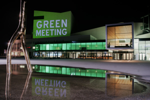 Der Bühnenturm des Festspielhauses grün beleuchtet mit dem Schriftzug Green Meeting