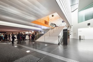 Menschen bei einem Empfang im Eingangsfoyer des Festspielhauses Bregenz mit Blick auf die weiße Hauptstiege