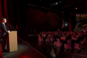 Redner am Pult auf einer Bühne vor einer Abendgesellschaft auf der Hauptbühne im Festspielhaus Bregenz