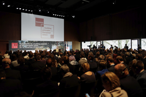 Ein Redner vor einer großen Leinwand und einer vollbesetzten Reihenbestuhlung im Seestudio des Festspielhauses Bregenz