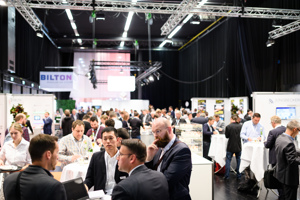 Gutbesuchte Ausstellungskojen auf der weiß eingeleuchteten Werkstattbühne im Festspielhaus Bregenz