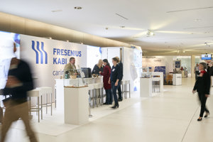 Besucher:innen gehen durch eine Fachausstellung und stehen an Ständen im weißen Foyer des Festspielhauses Bregenz