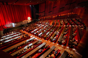 Vollbesetzter Großer Saal mit Parlamentbetischung und roten Sessel auf der Vorbühne im Festspielhaus Bregenz