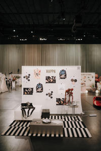 Messestand mit Bildern, Möbeln und Produkten auf einer abgegrenzten Fläche