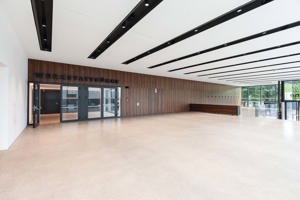 Großes, helles Foyer mit hellem Stein-Boden, Holzwand und Eingang zur Werkstattbühne