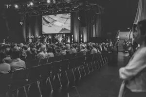 Tagungsteilnehmer:innen sitzen in Stuhlreihen auf der Werkstattbühne des Festspielhauses Bregenz © Büro Magma, Magdalena Türtscher