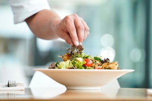 Eine Person garniert einen Salatteller im Festspielhaus Bregenz