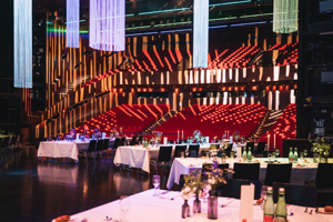 Bankettbetischung auf der Drehbühne, im Hintergrund ein rot bestuhltes, aufsteigendes Auditorium